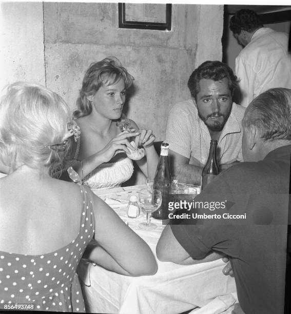 Film and television actress Ursula Andress with the director John Derek in a restaurant in Via Veneto, Rome in 1958.
