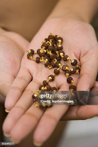 woman's hands with rudraksha beads - ayurveda kerala stock pictures, royalty-free photos & images