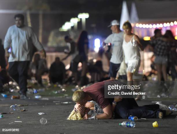 People lie on the ground at the Route 91 Harvest country music festival after apparent gun fire was hear on October 1, 2017 in Las Vegas, Nevada....
