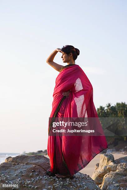 woman shielding eyes from sun, india - sari imagens e fotografias de stock