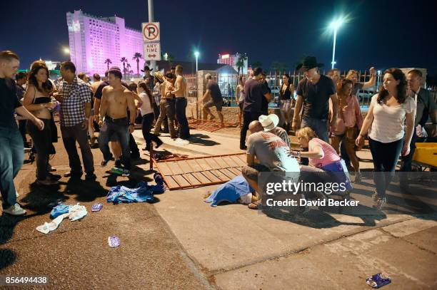 People tend to the wounded outside the Route 91 Harvest Country music festival grounds after an apparent shooting on October 1, 2017 in Las Vegas,...