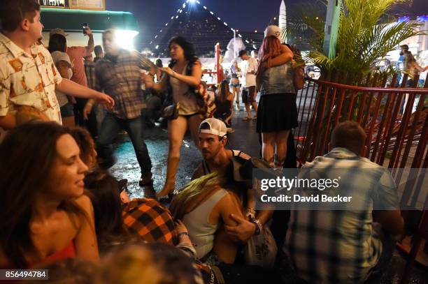 People run for cover at the Route 91 Harvest country music festival after apparent gun fire was heard on October 1, 2017 in Las Vegas, Nevada. There...