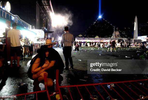 People take cover at the Route 91 Harvest country music festival after apparent gun fire was heard on October 1, 2017 in Las Vegas, Nevada. There are...
