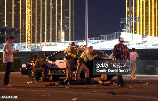 Las Vegas police stand guard along the streets outside the the Route 91 Harvest country music festival grounds after a active shooter was reported on...