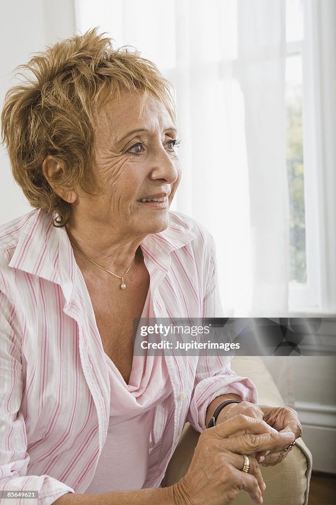 Smiling woman sitting beside window