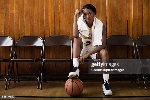 woman basketball player sitting on sideline - basketball sideline stock pictures, royalty-free photos & images