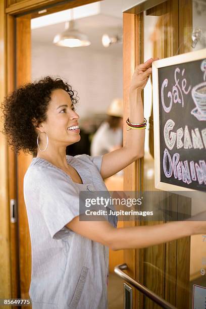 woman with grand opening sign for cafe - grand opening of empress restaurant in los angeles stockfoto's en -beelden