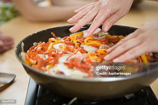 hands with sliced bell peppers in skillet - saute pan stock pictures, royalty-free photos & images