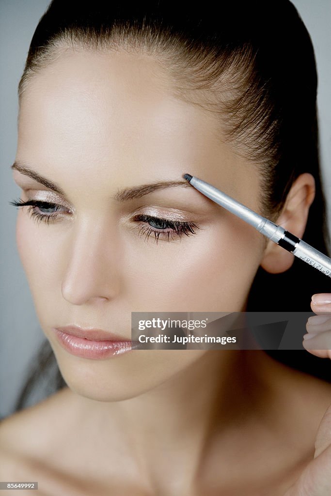 Woman using eyebrow pencil