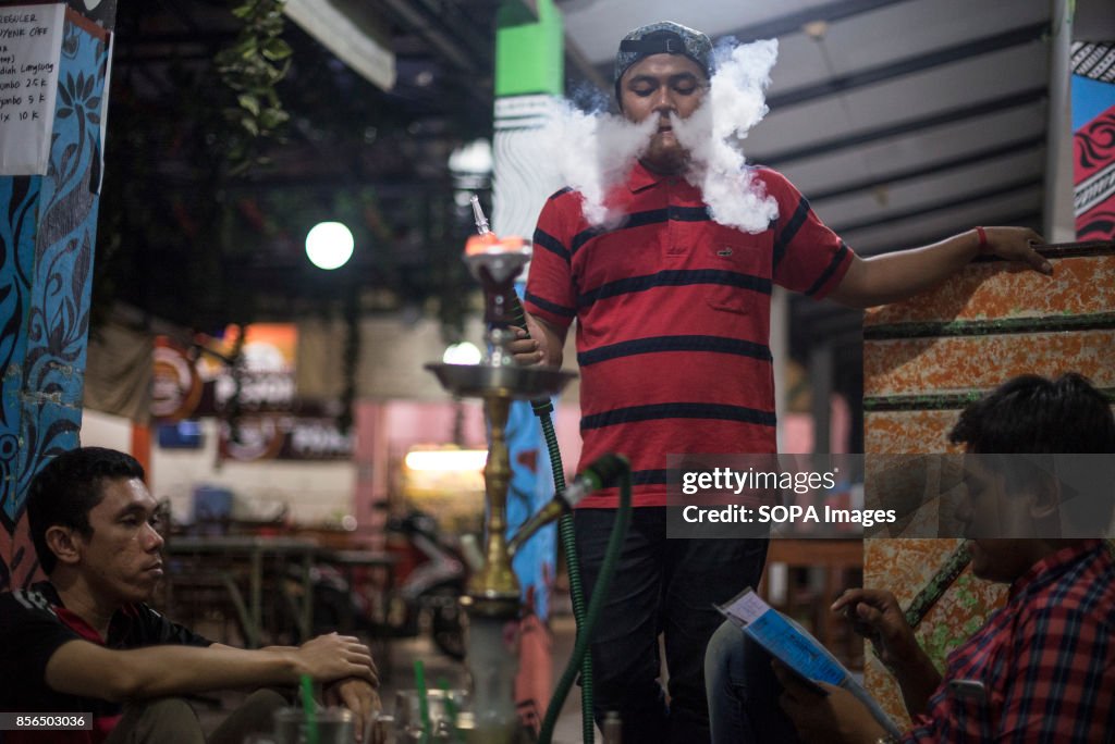 A group of friends are seen smoking shisha in a Warkop...