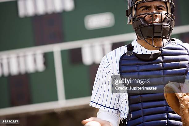 catcher standing in front of scoreboard - baseball catcher stock pictures, royalty-free photos & images