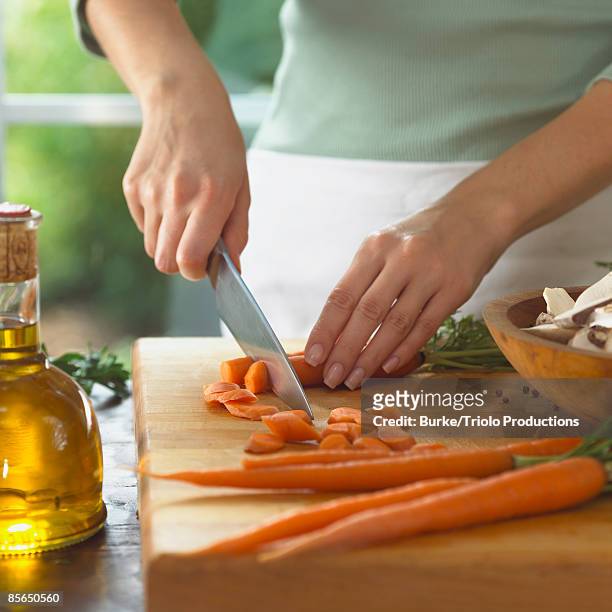 woman cutting carrots - cruet stock pictures, royalty-free photos & images