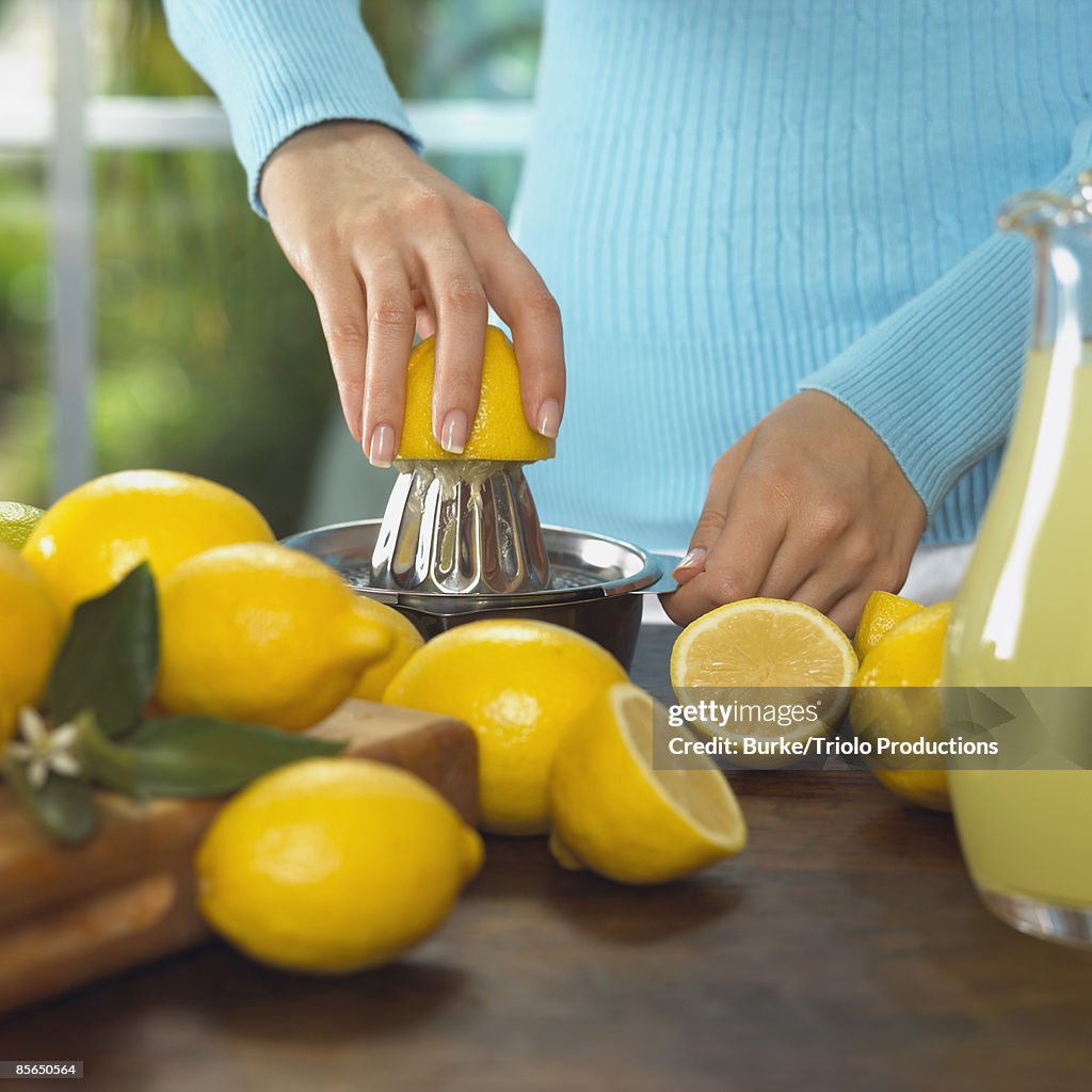 Woman squeezing lemons into lemonade