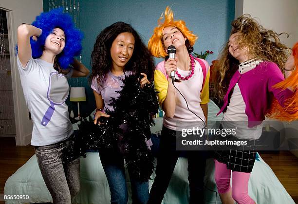 teenage girls in costumes singing - girls sleepover stock-fotos und bilder