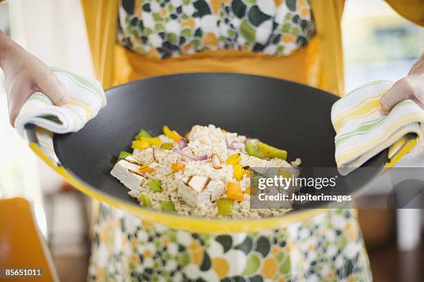 woman holding tofu vegetable stir fry in wok - stir frying european stock pictures, royalty-free photos & images