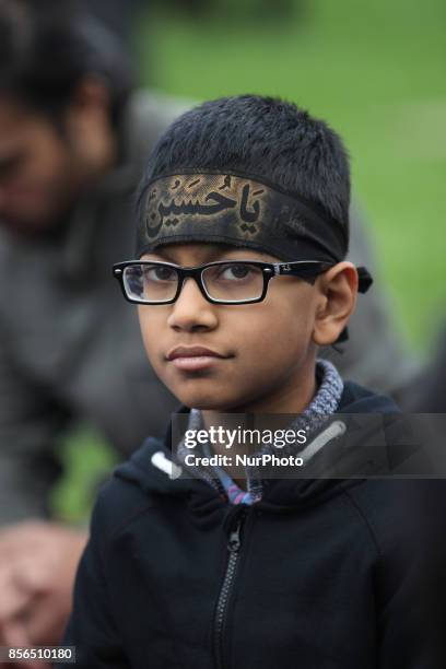 October 2016, Toronto, Ontario, Canada --- A young Shiite Muslim boy wearing a religious headband during the holy month of Muharram to commemorate...