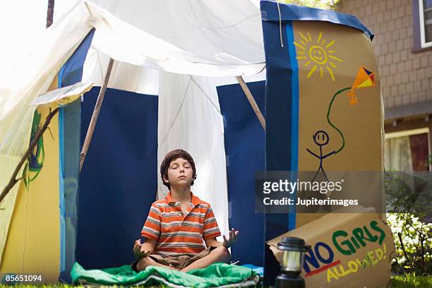 boy in playhouse meditating - mudra stock-fotos und bilder