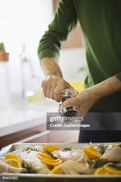 grinding pepper on orange rosemary chicken - grinding stock pictures, royalty-free photos & images