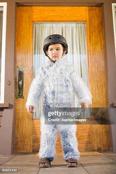 boy wearing bubble wrap and helmet - schutz stock-fotos und bilder