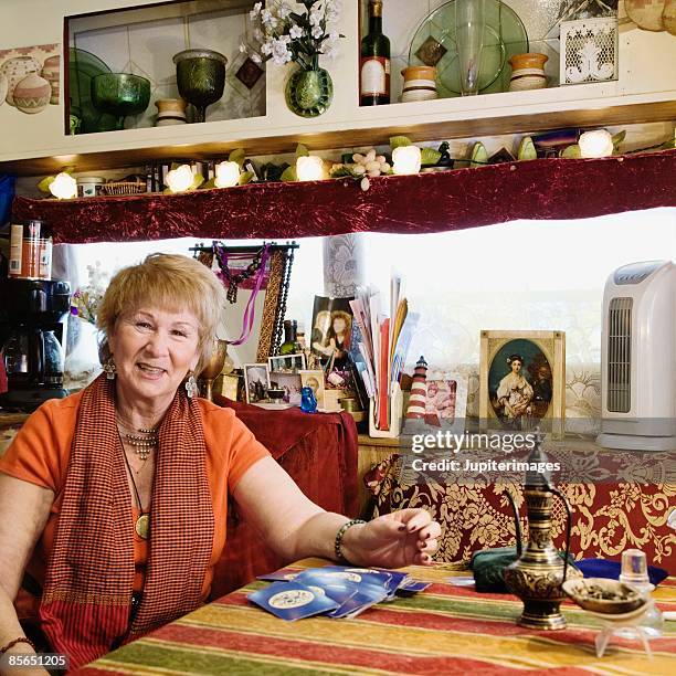 portrait of smiling fortune teller with tarot cards - fortune teller table stock pictures, royalty-free photos & images