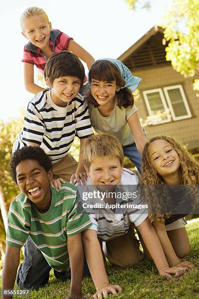 smiling children in pyramid formation - human pyramid stock pictures, royalty-free photos & images