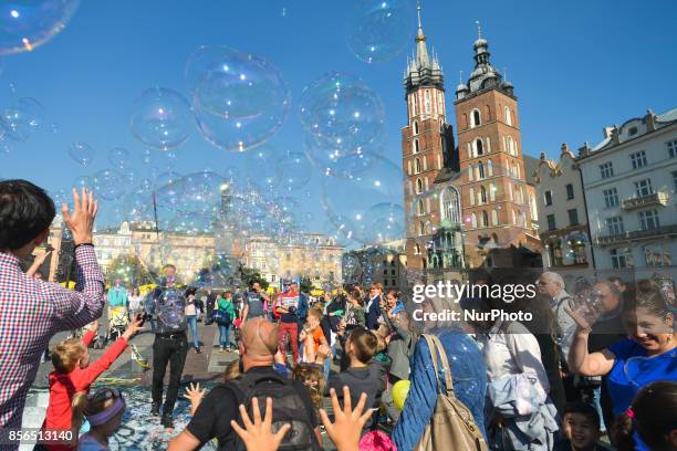 People and children in Krakow's Main Square enjoy soap bubbles games during the last days of warmth in the full sun, with temperatures reaching 20...