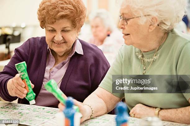 smiling women playing bingo - bingo stockfoto's en -beelden
