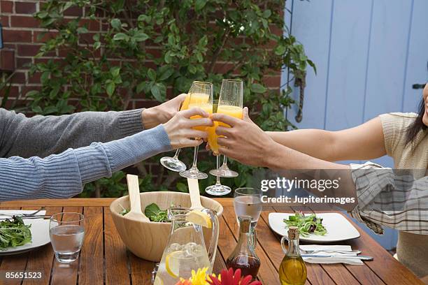 hands toasting with mimosas - brunch fotografías e imágenes de stock