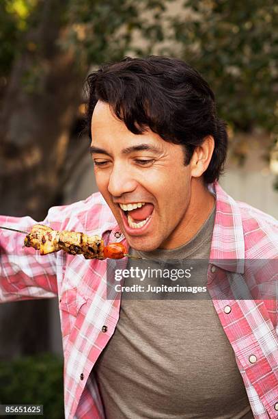 man eating grilled kebab - kebab stock pictures, royalty-free photos & images