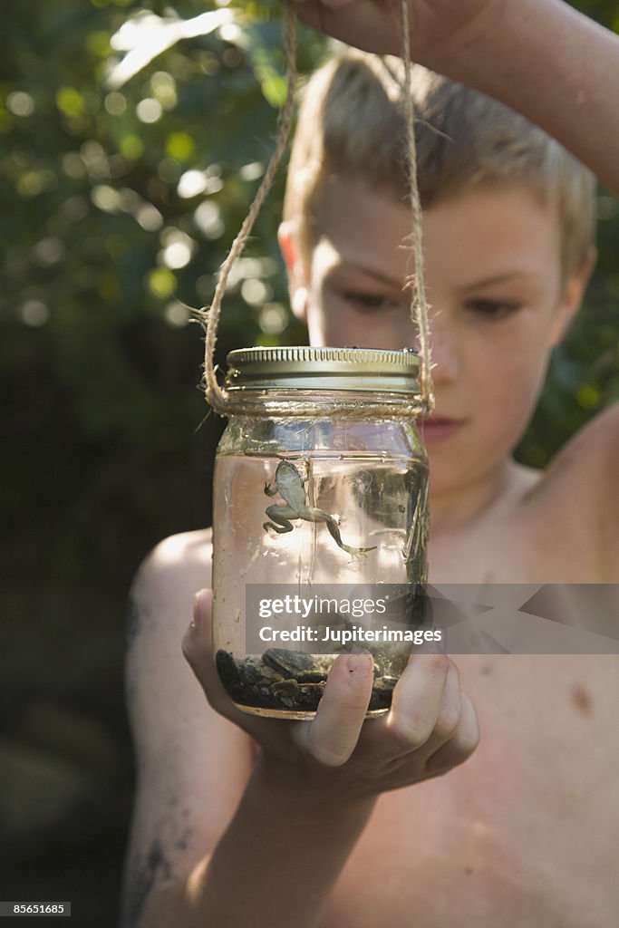 Boy looking into jar