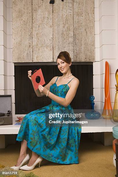 retro woman holding 45 rpm record - 45 rpm stock pictures, royalty-free photos & images