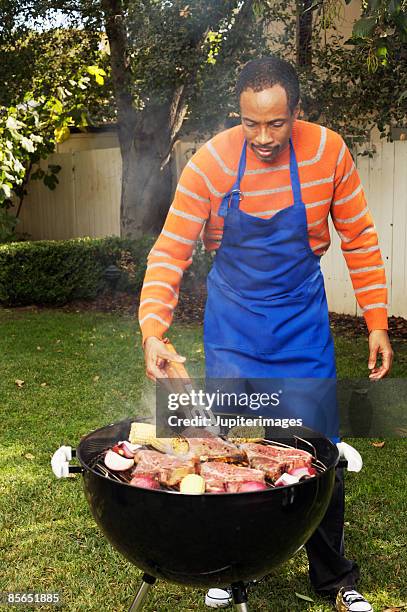 man grilling steaks and vegetables - bbq apron stock pictures, royalty-free photos & images