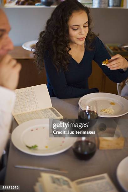 woman eating matzoh and karpas - karpas stockfoto's en -beelden