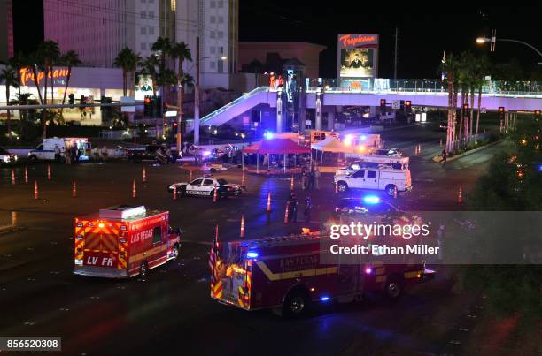 Police and rescue personnel gather at the intersection of Las Vegas Boulevard and Tropicana Ave. After a reported mass shooting at a country music...