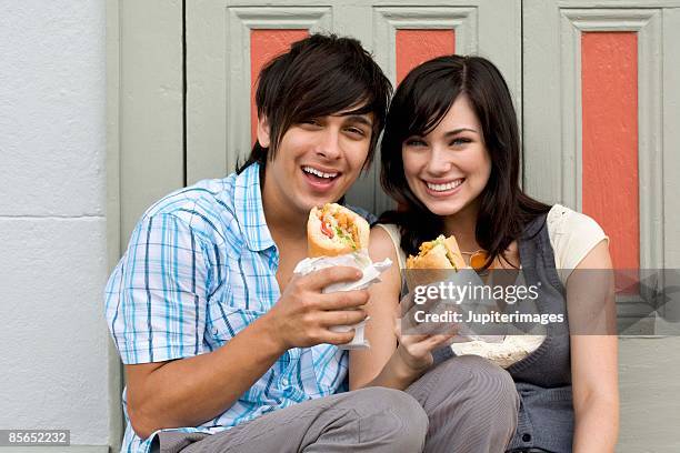 couple outdoors with sandwiches - eating cajun food stock pictures, royalty-free photos & images