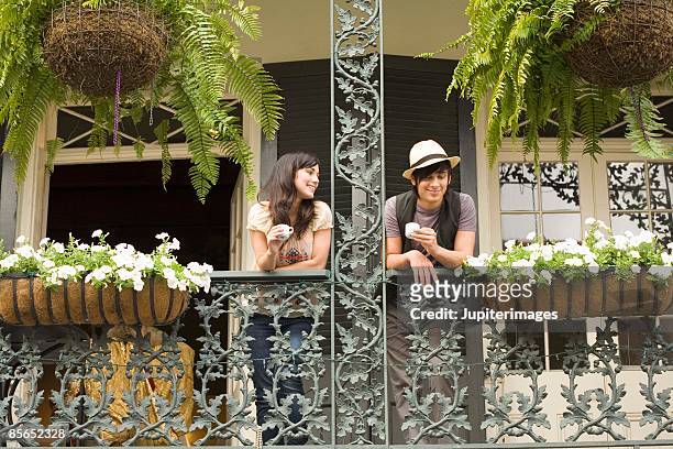 couple on balcony in new orleans, louisiana - new orleans stock pictures, royalty-free photos & images