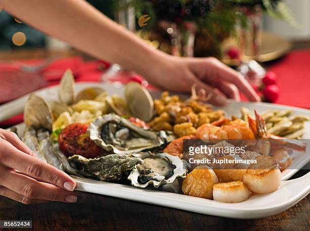 person with feast of the seven fishes seafood platter - seafood platter bildbanksfoton och bilder