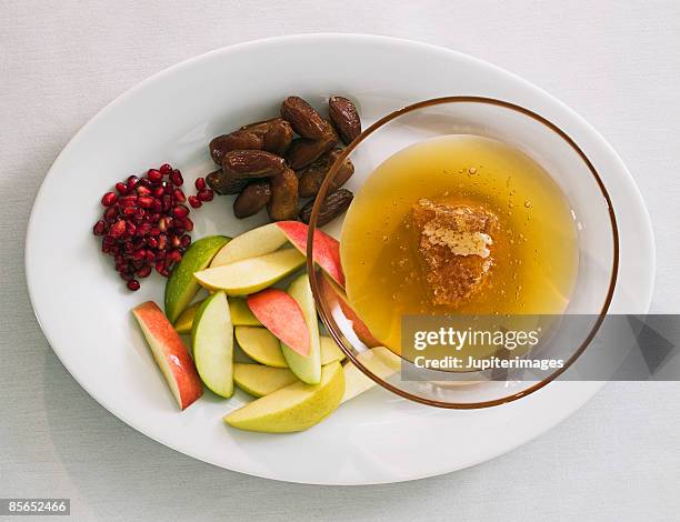 rosh hashanah fruit plate with honey - religious service stock-fotos und bilder