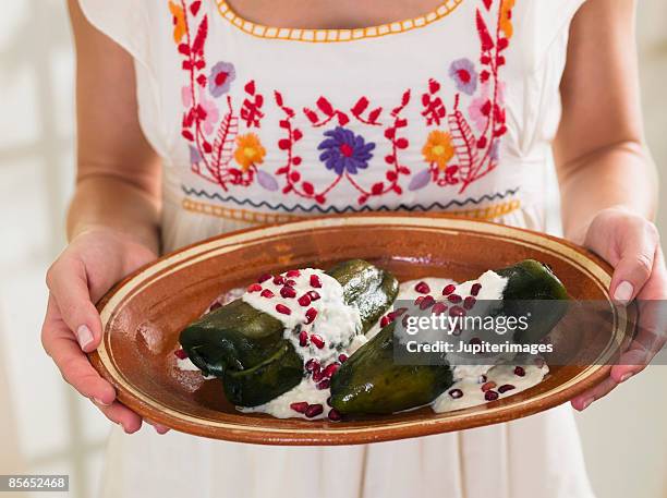 person holding platter of chiles en nogada - en cuisine stock pictures, royalty-free photos & images