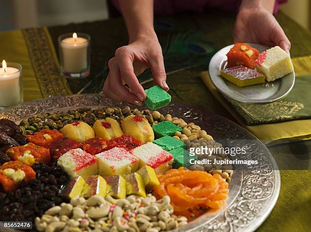 person with platter of diwali sweets - hinduism stockfoto's en -beelden