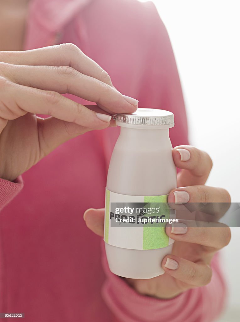 Person with bottle of probiotic drink