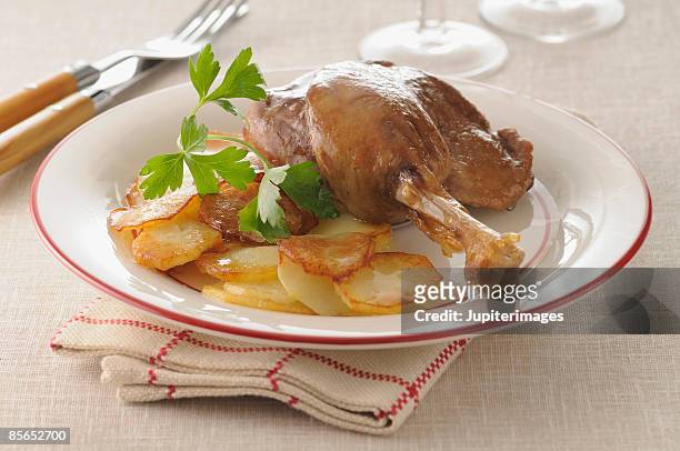roasted duck leg with potatoes - duck confit stockfoto's en -beelden