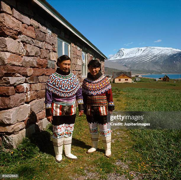 women by stone house , greenland - inuit people stock-fotos und bilder