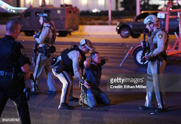 Police officers stop a man who drove down Tropicana Ave. Near Las Vegas Boulevard and Tropicana Ave, which had been closed after a mass shooting at a...