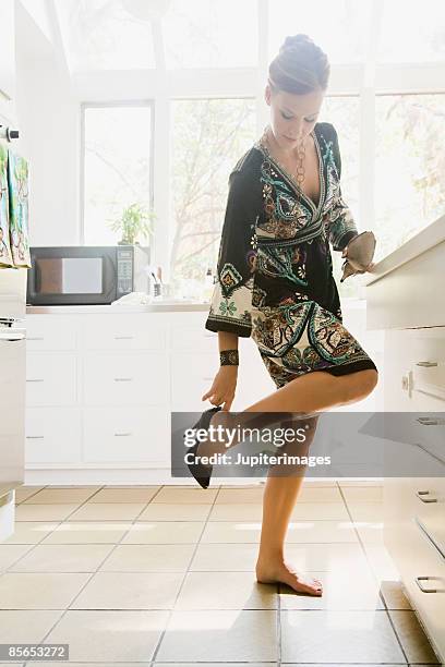 woman putting on shoe - high heel stockfoto's en -beelden