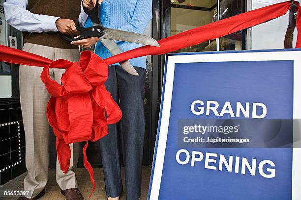 people cutting ribbon at grand opening of store - acto de apertura fotografías e imágenes de stock