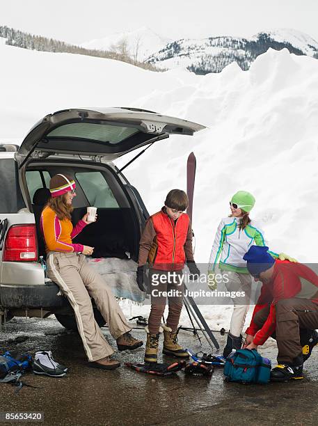 family on snowy mountain with suv and snowshoes - suv berg stock-fotos und bilder