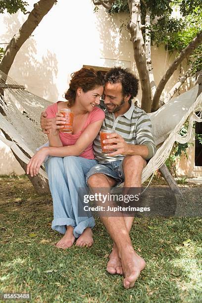 affectionate couple in hammock with beverages - gazpacho stock pictures, royalty-free photos & images