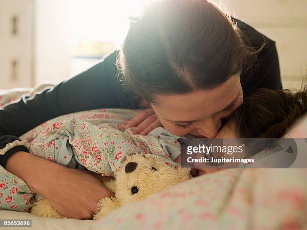 affectionate mother with daughter in bed - brunette woman bed stockfoto's en -beelden