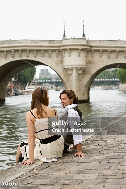 couple sitting together , river seine , paris , france - pont neuf stock pictures, royalty-free photos & images
